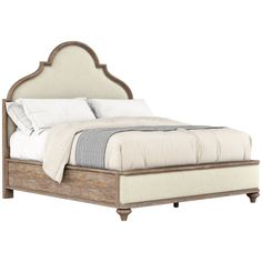 an upholstered bed with white linens and wood trim on the headboard