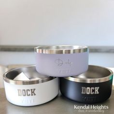 three different colored metal bowls sitting on top of a gray countertop next to each other