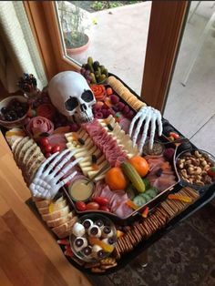 a tray filled with different types of food on top of a wooden table next to a window