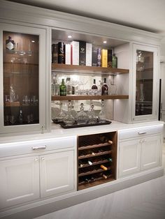 a kitchen with white cabinets and wine glasses