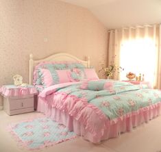 a bed with pink and blue bedspreads in a girls's bedroom,