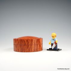 a wooden box sitting next to a small figurine