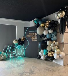 the balloon arch is decorated with black, white and gold balloons