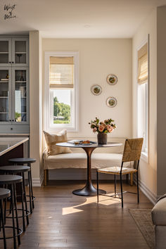 a living room filled with furniture next to a kitchen and dining room table in front of a window