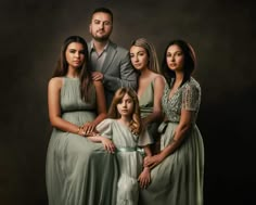 a family posing for a photo in front of a dark background