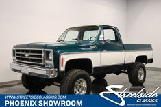 a green and white pick up truck on a checkered floor