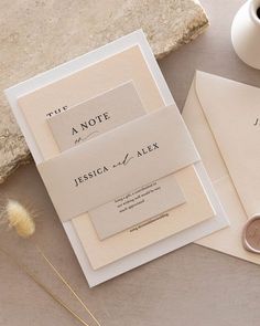 the wedding stationery is laid out on top of each other, including two envelopes and a wax stamp