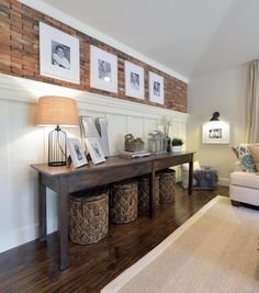 a living room with pictures hanging on the wall and two baskets under the coffee table