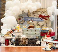 an airplane themed birthday party with white balloons