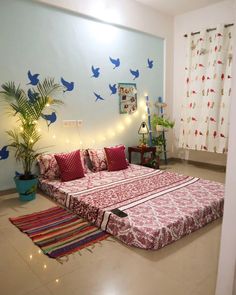 a bed sitting on top of a white floor next to a plant in a room