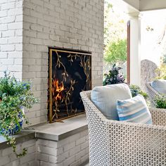 a living room filled with furniture and a fire place in front of a brick wall