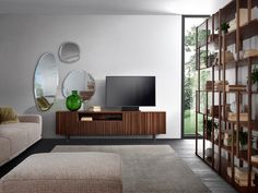 a living room filled with furniture and a flat screen tv sitting on top of a wooden shelf