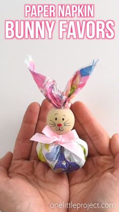 a hand holding a small bunny made out of candy wrappers with the words paper napkin bunny favors on it