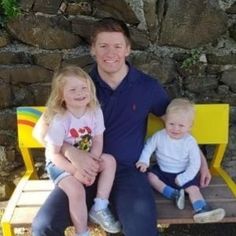 a man and two children sitting on a bench