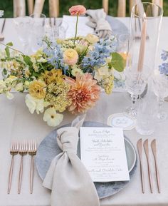 an image of a table setting with flowers and place settings on the table for dinner