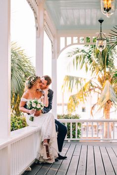 a bride and groom are kissing on the porch at their wedding venue in key west, florida