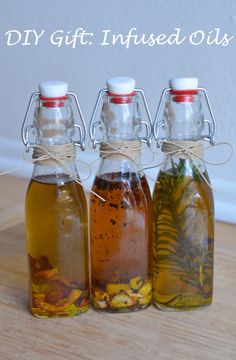 three bottles filled with liquid sitting on top of a wooden table