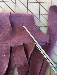 a pair of scissors and some purple fabric