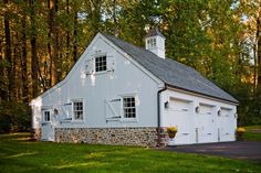 a white barn with two garages and a steeple