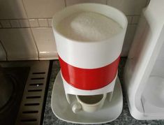 a white and red coffee maker sitting on top of a counter