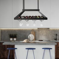 three stools sit in front of a kitchen island with wine glasses hanging from it