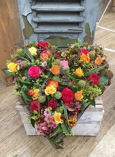 a heart shaped box filled with lots of flowers