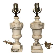 a pair of white marble lamps sitting on top of each other