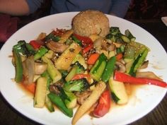 a white plate topped with stir fry vegetables