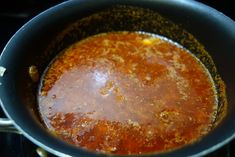 a pot filled with sauce sitting on top of a stove