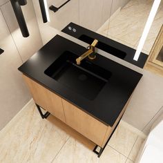 a black counter top with a gold faucet on it in front of a mirror