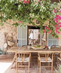 an outdoor dining area with table, chairs and potted plants hanging over it's head