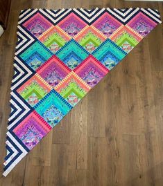 a multicolored quilt is laying on the floor