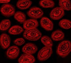 some red balls with an eye drawn on them in front of a black background,