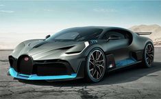 the bugatti supercar is parked in an empty lot with mountains in the background