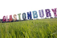 a field that has some type of sign in the grass with words written on it