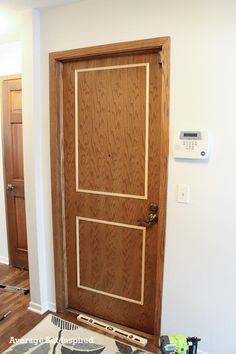 a wooden door in the middle of a room with tools on the floor next to it