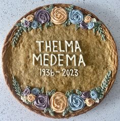 a cake decorated with flowers and the name themma medema on it's side