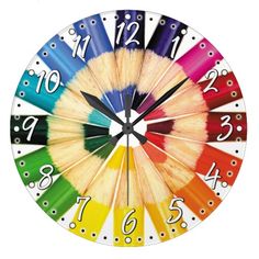 a clock made out of colored pencils with numbers painted on the face and hands