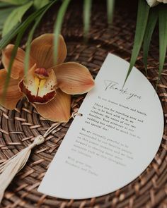 a close up of a flower on a wicker basket with a note attached to it