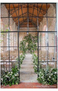 an outdoor wedding ceremony with flowers and greenery on the arch, surrounded by chairs