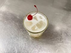 a drink with ice cubes and a cherry on top