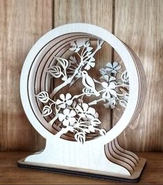 a wooden clock with flowers and birds on it's face in the shape of a circle