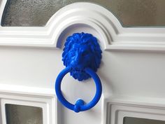 a blue lion head ring handle on a white door