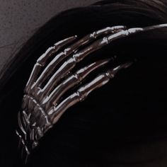 a skeleton hand is attached to the back of a woman's head with long hair