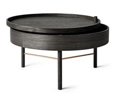 a round table with two black trays on each side and an iron stand in the middle