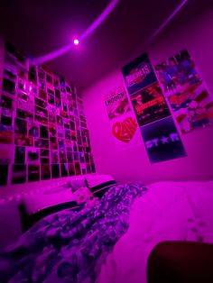 a bedroom with pink lighting and posters on the wall