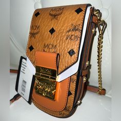 Bnwt Mcm Patricia Crossbody Visetos Cell Phone Case Bag, $750 (+ $75 Ca Tax). From Saks (See Order Screenshot & Receipt). Comes As Pictured: Strap, Plate & Gold Grommets Are Still Wrapped In Plastic! Also Comes With Mcm Branded Dustbag & Care/Authenticity Cards!! Please No Offers / Trades / Emails / Bundling Discounts / Negotiating In Comments R E M E M B E R: Best Price Is Already Listed.You Pay=$625, I Earn=$500 Price Is Firm! Trading For Only! Orders >= $500 Are Authenticated By Posh!! Ships Luxury Orange Pouch Shoulder Bag, Luxury Orange Shoulder Bag, Orange Rectangular Shoulder Bag With Branded Hardware, Luxury Orange Bag With Gold-tone Hardware, Luxury Orange Rectangular Shoulder Bag, Luxury Orange Rectangular Bag, Luxury Orange Evening Bag, Luxury Orange Evening Bags, Luxury Orange Shoulder Bag For Daily Use