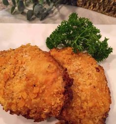 two fried chicken patties with parsley on the side