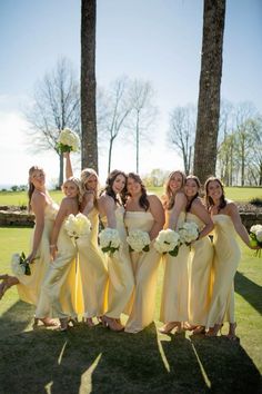 a group of women in yellow dresses standing next to each other