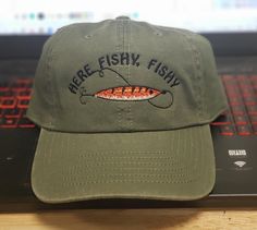 there is a green hat that says here fishy on the front and side of it